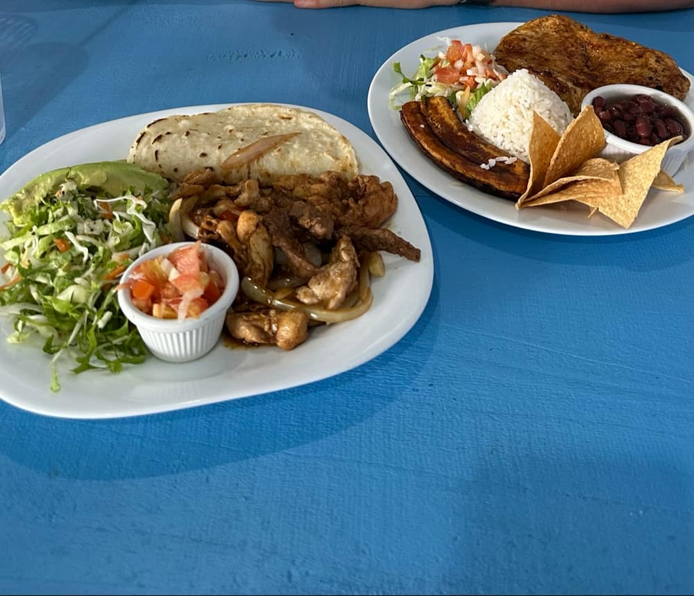 Fajitas y casado servidos sobre la icónica mesa azul de El Turnito