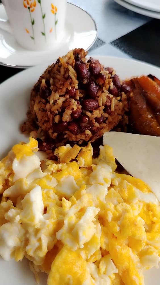 Gallo pinto con huevos revueltos, queso y maduro